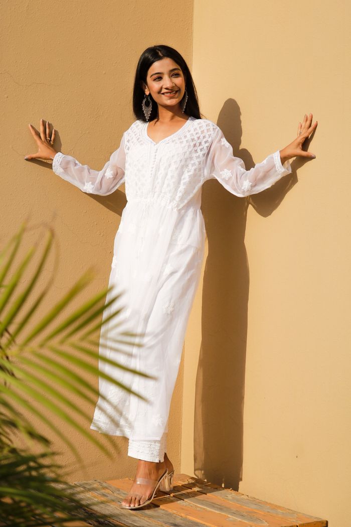 Stylish woman in a white chikankari kurti outdoors, showcasing ethnic elegance.