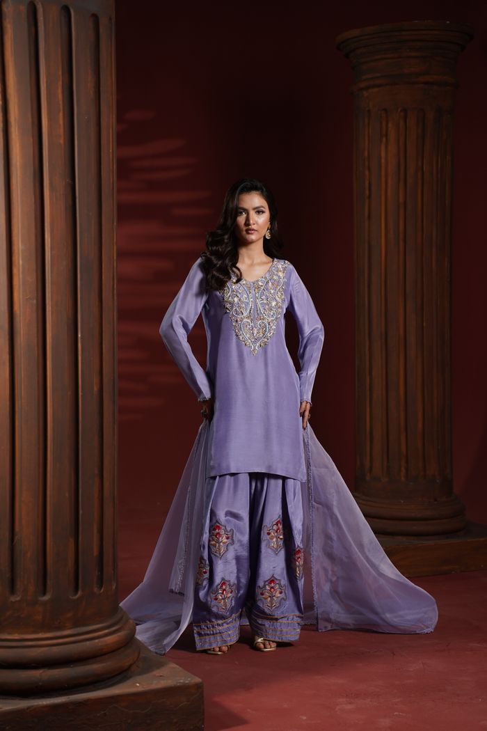 Striking portrait of a model in exquisite traditional attire with ornate columns.